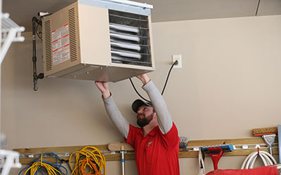 Heartland technician installing a garage heater